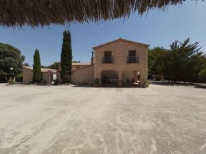 une grande maison en pierre avec une grande allée. dans l'établissement El Rulón, gran villa rural con piscina privada, à Alicante