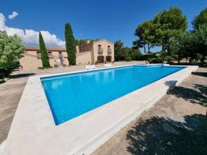 a large swimming pool in front of a house at El Rulón, gran villa rural con piscina privada in Alicante