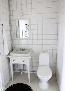 a white bathroom with a sink and a toilet at Brobacka Gästhem in Jomala