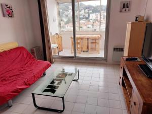 un soggiorno con divano rosso e tavolo di Appt F2, Centre ville, 700m de la plage a Cannes