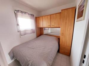 a small bedroom with a bed and wooden cabinets at Appt F2, Centre ville, 700m de la plage in Cannes