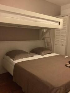 a bedroom with a bunk bed with a white bunk bedutenewayangering at VILLA ALIZÉE Logement 3 in Sainte-Rose +5 photos