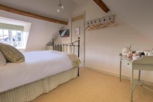 Schlafzimmer mit einem Bett, einem Tisch und einem Fenster in der Unterkunft The Ship At Dunwich in Dunwich