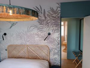 a bedroom with a bed with a floral wallpaper at Les Galets Hôtel et B&B in Bandol