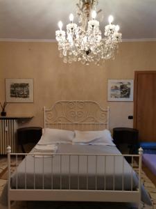 a bedroom with a large bed with a chandelier at B&B Sotto le Mura in Bergamo
