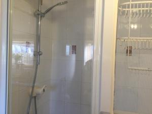 a bathroom with a shower with a glass door at The Annex Rocket cottage in Sidestrand