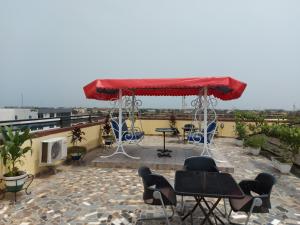 un patio con mesas y sillas en la azotea en Room in Guest room - Royal Blue Guest House Bar Deluxe Twin Bed, en Lomé