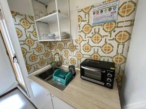 Una pequeña cocina con microondas y fregadero. en BeachFront, en Giardini Naxos