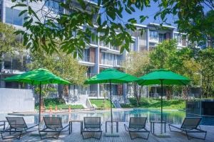 a group of chairs and umbrellas next to a pool at 2 Bedroom Khaoyai Poolsuite by Nancy in Ban Huai Sok Noi
