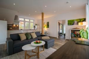 a living room with a couch and a table at Alte Mühle Hotel & Restaurant in Rödental