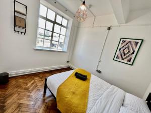 1 dormitorio con 1 cama con asiento amarillo en The Bristol Wing en Bristol