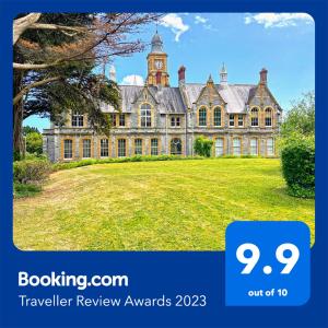 a large mansion with a clock tower on top at Luxury 1 Bedroom Duplex with Free Parking in Plymouth