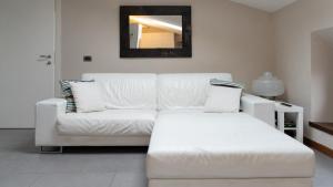 uma sala de estar com um sofá branco e um espelho em Villa Riva Lago em Tavernola Bergamasca