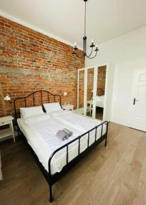 a bed in a room with a brick wall at Chabrowy - Apartamenty Smart Projekt in Tarnów