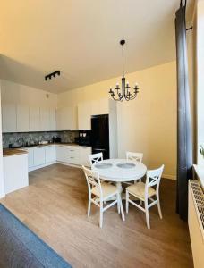 a dining room with a table and chairs in a kitchen at Chabrowy - Apartamenty Smart Projekt in Tarnów