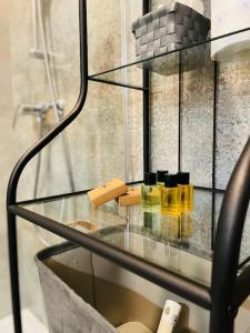 un estante de cristal con cosméticos en el baño en Chabrowy - Apartamenty Smart Projekt en Tarnów