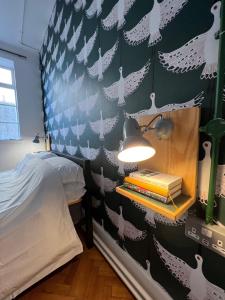 ein Schlafzimmer mit einem Bett und einer Wand mit weißen Vögeln in der Unterkunft The Bristol Wing in Bristol
