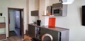 a kitchen with a counter with a microwave on the wall at Zur Eiche - Ferienwohnung in Böhlen +8 photos