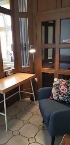 a living room with a blue couch and a desk at Zur Eiche - Ferienwohnung in Böhlen