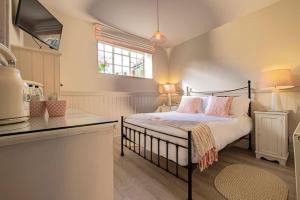 een slaapkamer met een bed met roze kussens erop bij The Ship At Dunwich in Dunwich