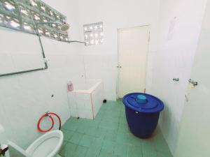 ein Badezimmer mit einem WC und einem blauen Mülleimer in der Unterkunft Homestay Kuala Terengganu One Stop 2 in Kuala Terengganu