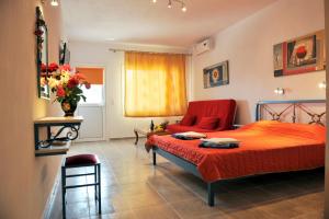 メガリ・アモスにあるFengeros Villageのベッドルーム(赤いベッド1台、ソファ付)