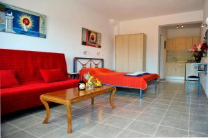 a living room with a red couch and a table at Fengeros Village in Megali Ammos