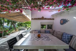 een eetkamer met een tafel en stoelen en bloemen bij Vrisidia Cottage - Nature, Seaview & Relax in Plakias