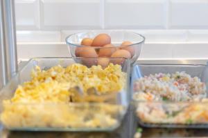 three plastic containers of food on a counter with eggs at Hotel La Milagrosa in Alicante