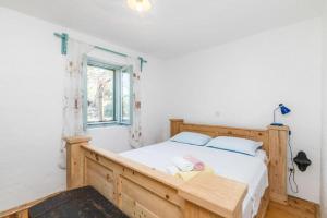 a bedroom with a wooden bed and a window at Lavender Cottage in Trpanj