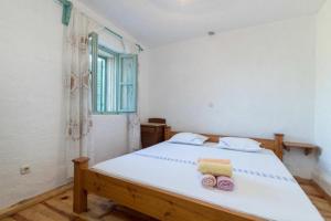 a bedroom with a large white bed with towels on it at Lavender Cottage in Trpanj