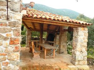 a stone patio with a wooden table and a roof at Lavender Cottage in Trpanj