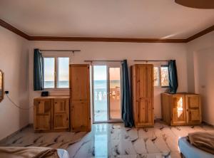 Cette chambre dispose de portes et de fenêtres offrant une vue sur l'océan. dans l'établissement Zarnouk beach house, à Dahab