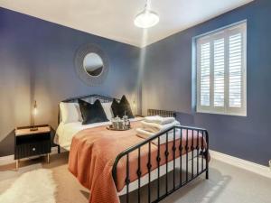 a blue bedroom with a bed and a mirror at Stoney Nook Cottage in Guisborough