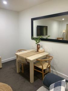 a table and chairs in a room with a mirror at Pier 108 Glenelg in Glenelg