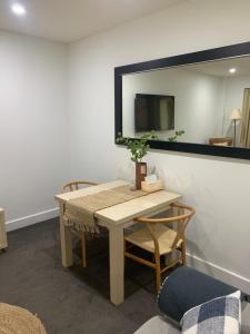 - une table et des chaises dans une pièce avec un miroir dans l'établissement Pier 108 Glenelg, à Glenelg