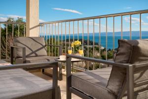 two chairs and a table on a balcony with the ocean at Sun Spalato Hills 7 in Split