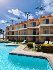 a large apartment building with a swimming pool at Parador Palmas de Lucia in Yabucoa
