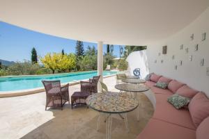 a patio with tables and chairs and a pool at Villa Nymphée in Vaison-la-Romaine