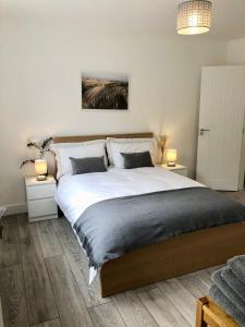 een slaapkamer met een groot wit bed met 2 lampen bij Spacious En-suite Private Double Bedroom in Oxford