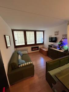 a living room with a couch and a christmas tree at CASA DESIRE' in Piancavallo