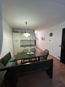 a living room with a table and chairs and a kitchen at CASA DESIRE' in Piancavallo