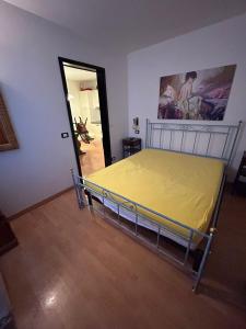 um quarto com uma cama com um lençol amarelo em CASA DESIRE' em Piancavallo
