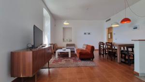 sala de estar con sofá, TV y mesa en BayWatch - Via Perarolo 8 en Trieste