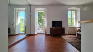 uma sala de estar com uma televisão de ecrã plano e janelas em BayWatch - Via Perarolo 8 em Trieste