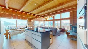 ヴェゾナにあるEgg SAUNA & LUXURY chalet 16 pers by Alpvision Résidencesのキッチン、木製の天井と窓のあるリビングルーム