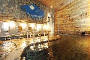 una piscina en una habitación con pared de roca en La'gent Stay Sapporo Odori Hokkaido, en Sapporo