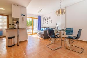 Renteando Albir Apartments في البير: مطبخ وغرفة معيشة مع طاولة وكراسي