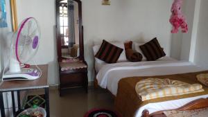 a bedroom with two beds and a fan at Secret View Homestay Ella in Ella