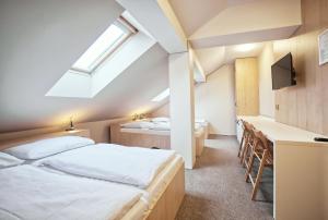 um quarto com 2 camas, uma secretária e uma janela em Restaurace a Penzion Praha em Dolní Dunajovice
